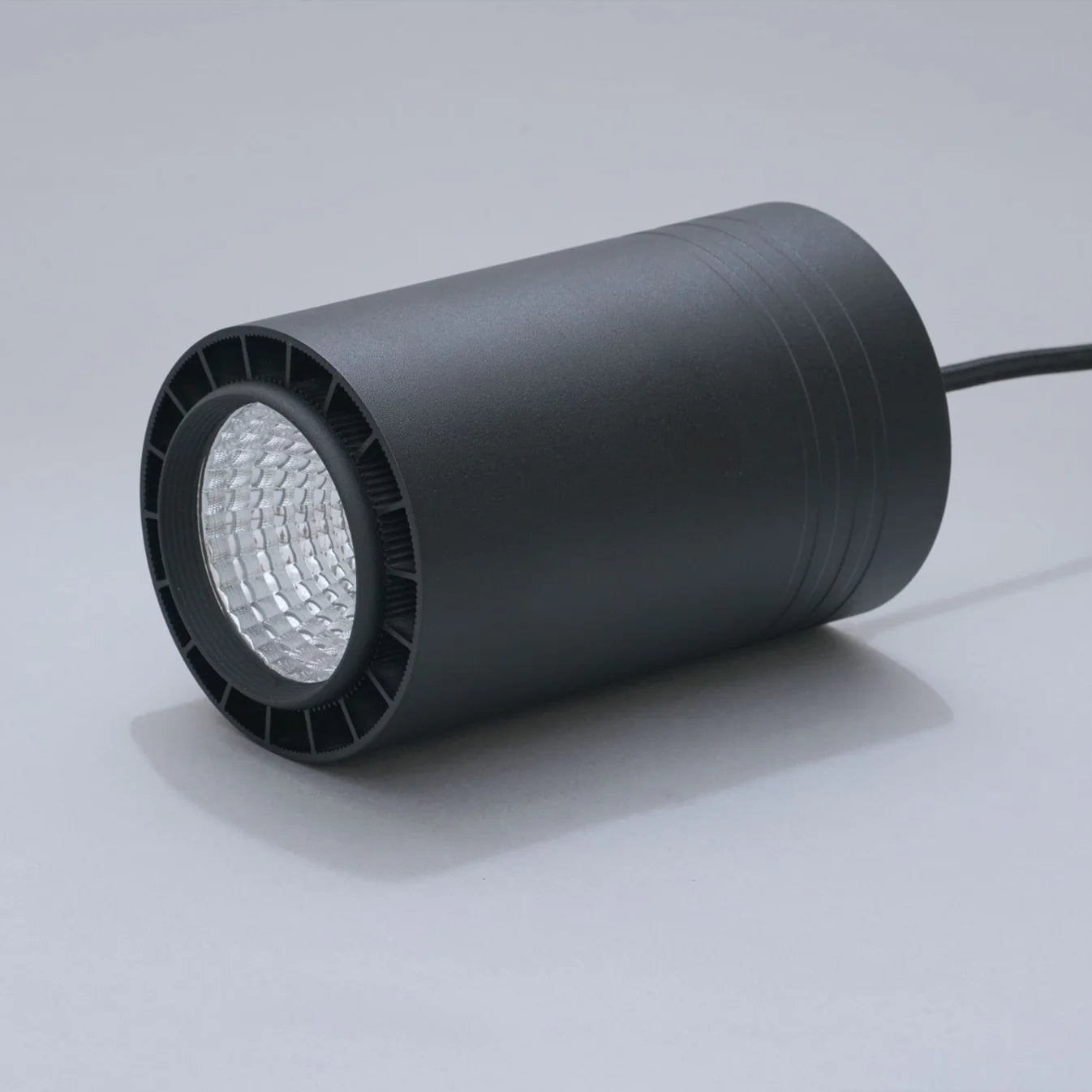 Black cylindrical light fixture on a gray background